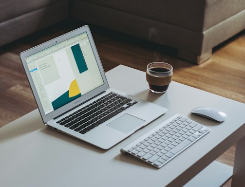 A warm, inviting office space with a laptop open on a desk and a coffee cup beside it